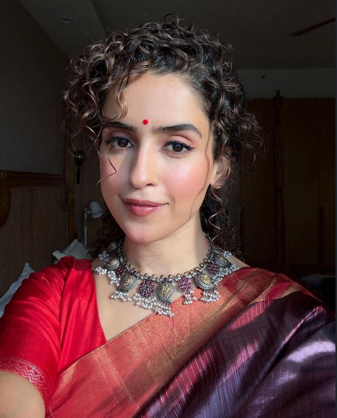 Sanya brings fun and individuality into her red fits, adding quirk to tradition.